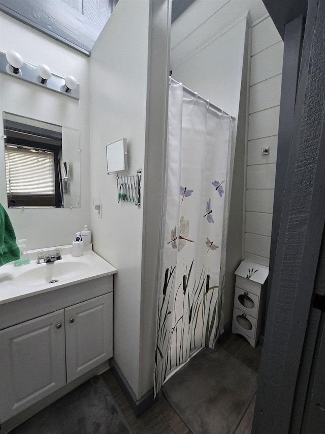bathroom featuring a shower with shower curtain, wood finished floors, and vanity