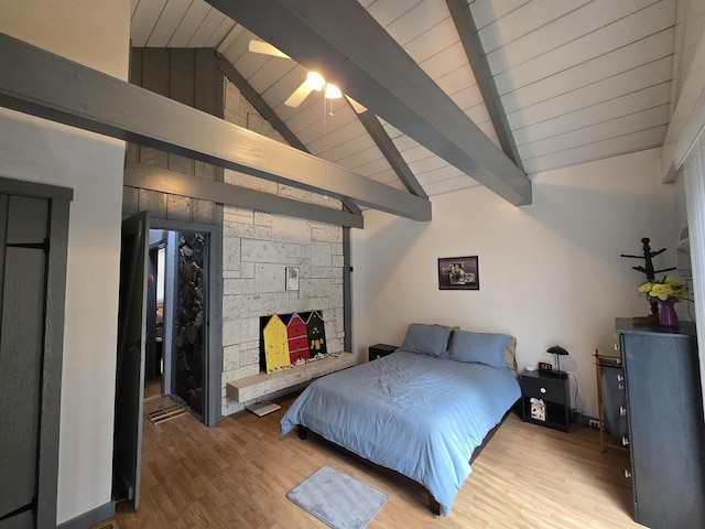 bedroom featuring light wood-style flooring and vaulted ceiling with beams