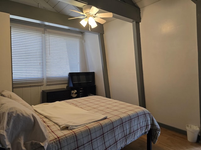 bedroom featuring vaulted ceiling, a ceiling fan, baseboards, and wood finished floors