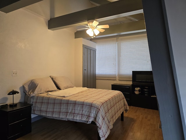 bedroom with ceiling fan, wood finished floors, and beamed ceiling