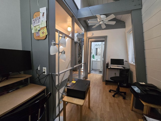 office space featuring vaulted ceiling with beams, light wood-style floors, and a ceiling fan