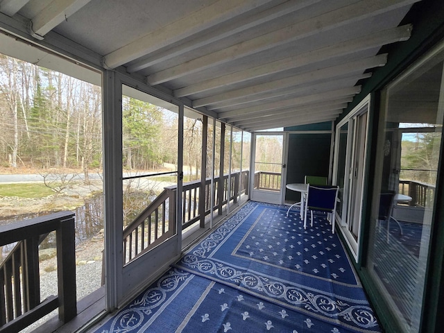 unfurnished sunroom with beamed ceiling
