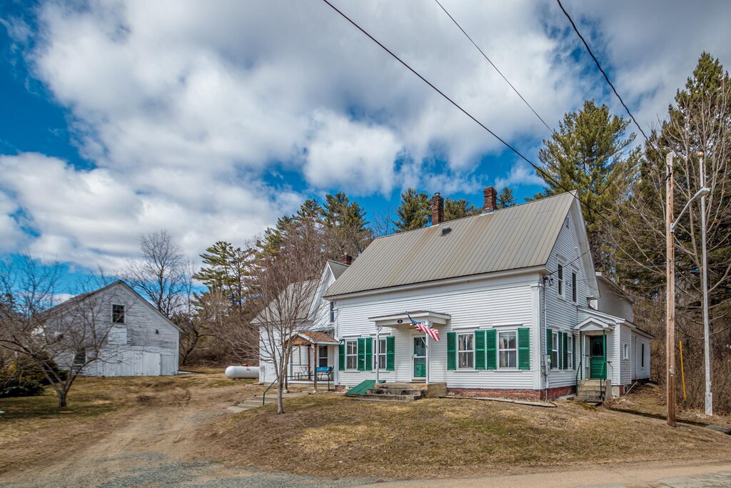 view of front of house featuring a chimney, metal roof, and dirt driveway
