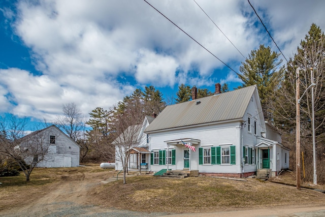 view of front of house featuring a chimney, metal roof, and dirt driveway