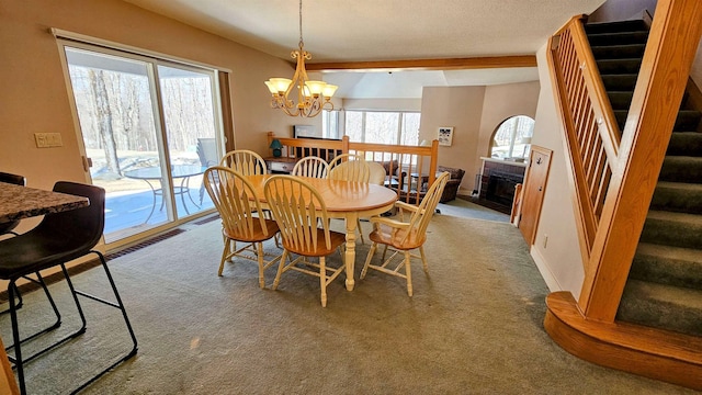 carpeted dining room featuring stairs, a chandelier, a fireplace, a textured ceiling, and baseboards