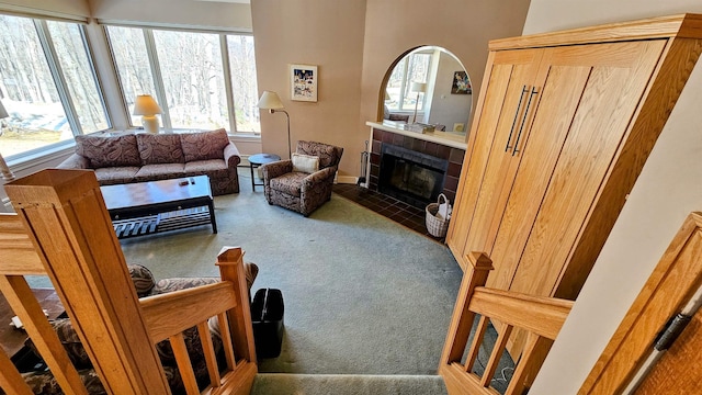 living room featuring a tiled fireplace and carpet