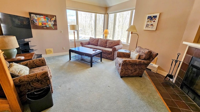living area with carpet floors, baseboards, visible vents, and a tile fireplace