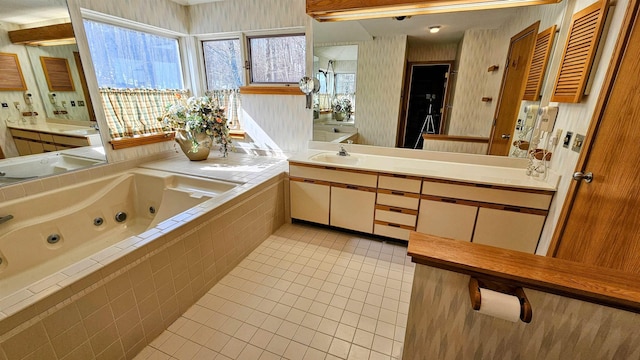 full bathroom featuring a tub with jets, tile patterned flooring, and vanity