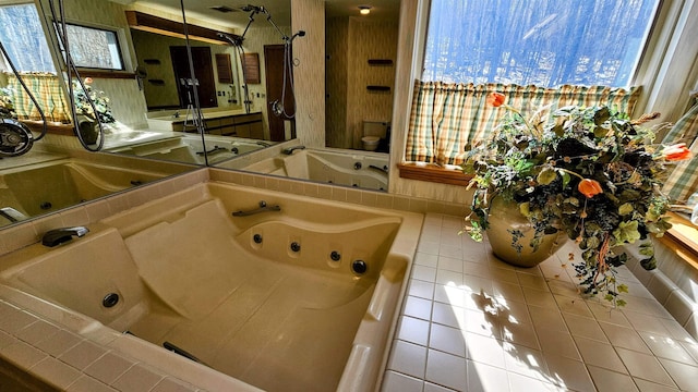 bathroom featuring tile patterned floors, toilet, and a jetted tub