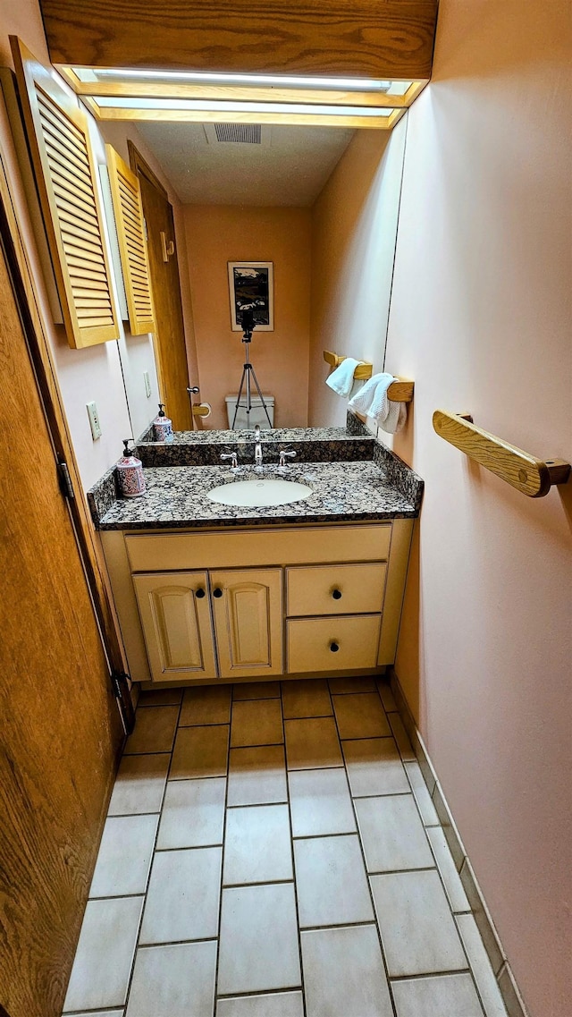 bathroom featuring tile patterned floors, baseboards, and vanity