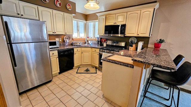 kitchen with a breakfast bar area, appliances with stainless steel finishes, and a peninsula
