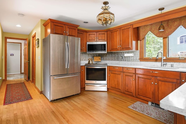 13 Ocean Circuit Dr, York, ME 03902 - kitchen with a sink, brown cabinetry, light wood-type flooring, and appliances with stainless steel finishes