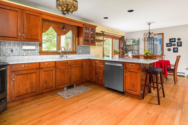 13 Ocean Circuit Dr, York, ME 03902 - kitchen with a kitchen bar, a sink, dishwasher, a peninsula, and a notable chandelier