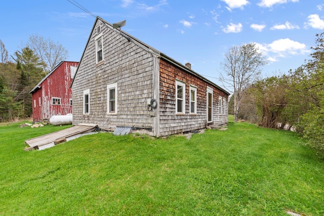 view of side of property with a lawn and a chimney