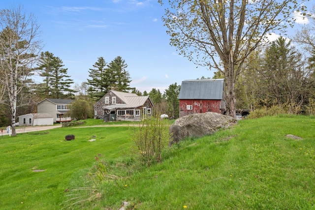 view of green lawn with an outbuilding and a barn