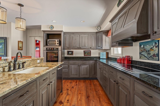 444 Tin Shanty Rd, Shrewsbury, VT 05738 - kitchen with custom range hood, hardwood / wood-style floors, stainless steel appliances, dark stone counters, and a sink