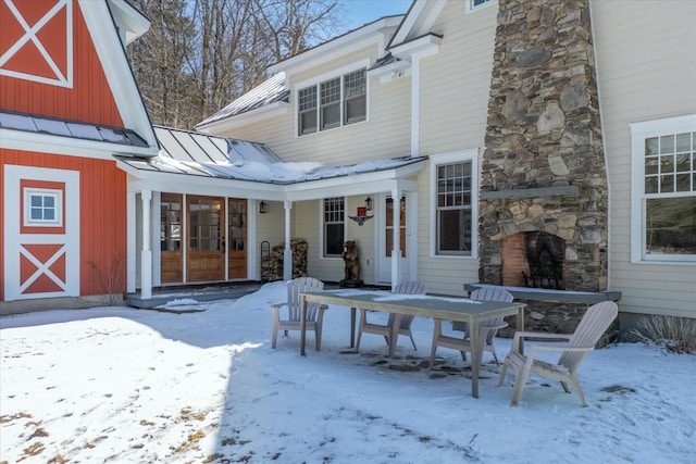 444 Tin Shanty Rd, Shrewsbury, VT 05738 - snow covered back of property with metal roof, an outdoor stone fireplace, a standing seam roof, and a patio