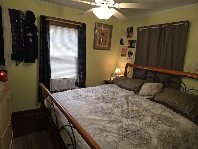 bedroom featuring baseboards, wood finished floors, ceiling fan, and ornamental molding