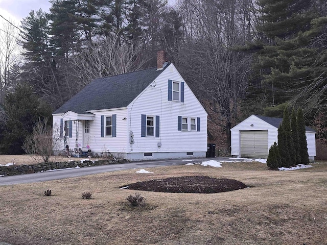 cape cod home featuring a chimney, an outbuilding, a detached garage, and roof with shingles