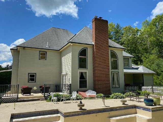103 Renshaw Rd, Weare, NH 03281 - rear view of house featuring a wooden deck, a patio, a chimney, and a shingled roof