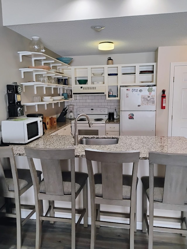 kitchen with white appliances, open shelves, a sink, extractor fan, and decorative backsplash