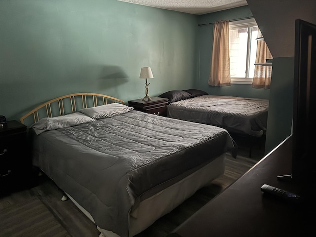 bedroom featuring wood finished floors and a textured ceiling