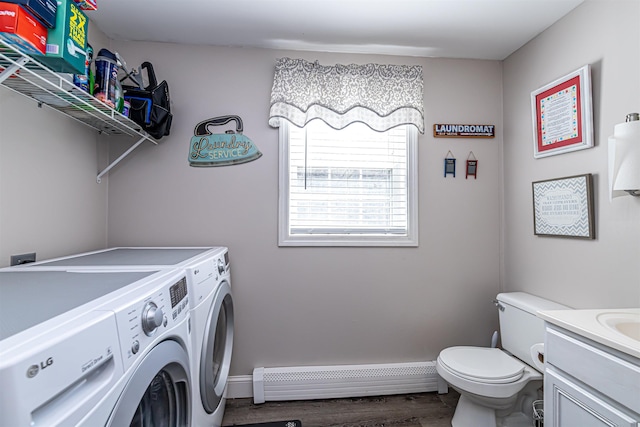 washroom with baseboards, laundry area, washer and dryer, a baseboard radiator, and wood finished floors