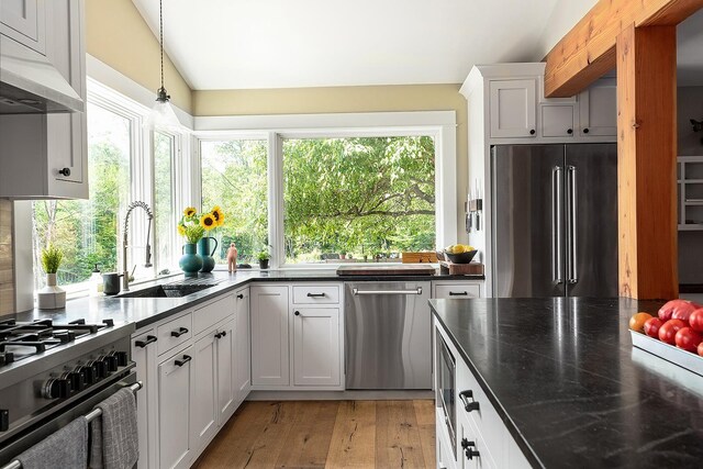 437 Lonesome Trl, Waterbury, VT 05676 - kitchen featuring a sink, lofted ceiling, under cabinet range hood, stainless steel appliances, and a healthy amount of sunlight