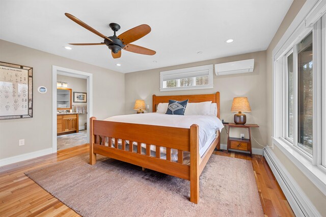 437 Lonesome Trl, Waterbury, VT 05676 - bedroom with a wall mounted AC, recessed lighting, baseboards, light wood-style floors, and a baseboard radiator