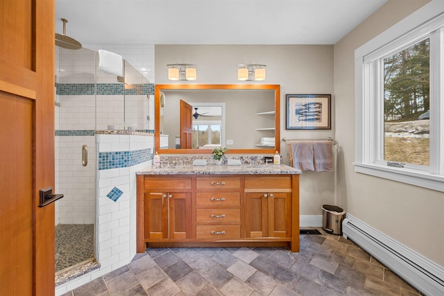 437 Lonesome Trl, Waterbury, VT 05676 - bathroom featuring double vanity, a healthy amount of sunlight, baseboard heating, and a shower stall