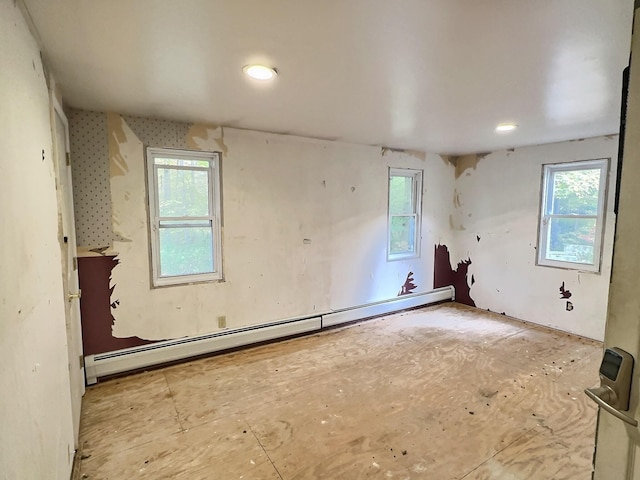 empty room featuring a healthy amount of sunlight and a baseboard radiator