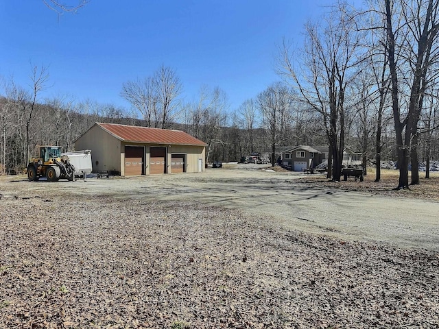 view of yard with a detached garage and an outbuilding