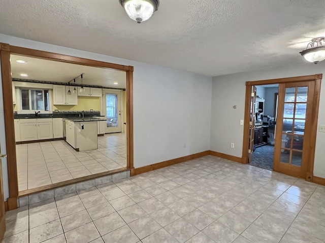 kitchen featuring a textured ceiling, a sink, and dark countertops