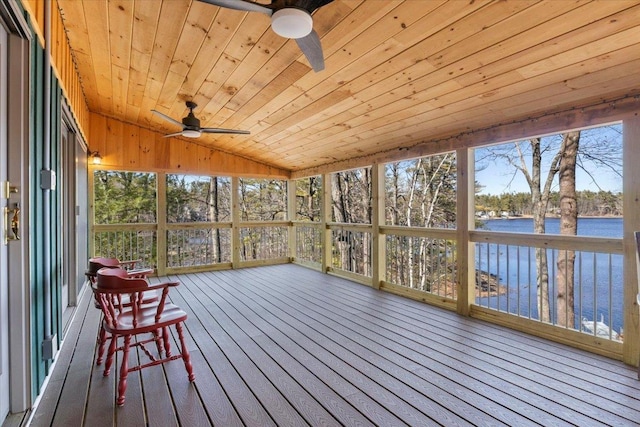 unfurnished sunroom featuring a wealth of natural light, a ceiling fan, and a water view