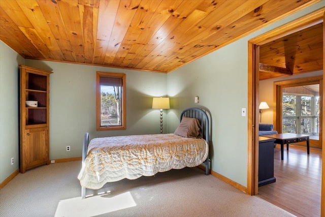 carpeted bedroom featuring wooden ceiling, baseboards, and ornamental molding