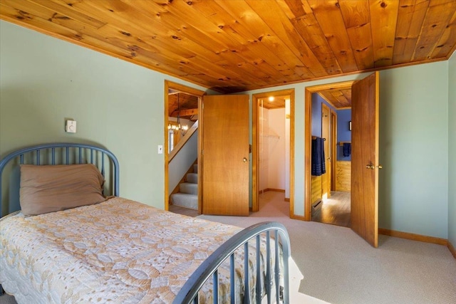 carpeted bedroom with baseboards and wooden ceiling