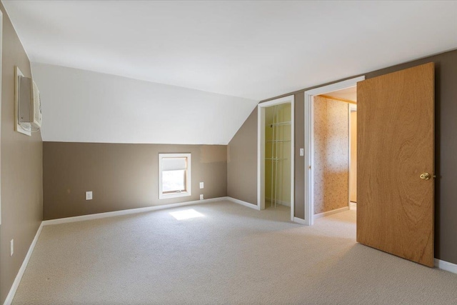 bonus room with baseboards, vaulted ceiling, and light carpet