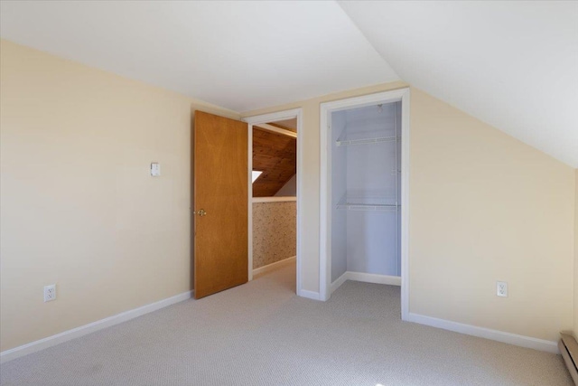 bonus room featuring light carpet, a baseboard heating unit, baseboards, and lofted ceiling