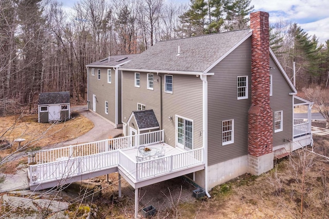 72 Natures Way, Wells, ME 04090 - rear view of property featuring a chimney, a storage shed, an outdoor structure, a shingled roof, and a deck