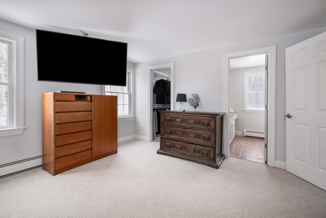 72 Natures Way, Wells, ME 04090 - bedroom with a baseboard heating unit, light carpet, a walk in closet, and multiple windows