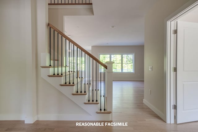 stairway featuring baseboards and wood finished floors