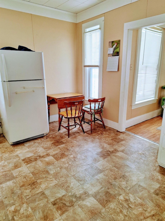 dining space with plenty of natural light, stone finish flooring, and baseboards