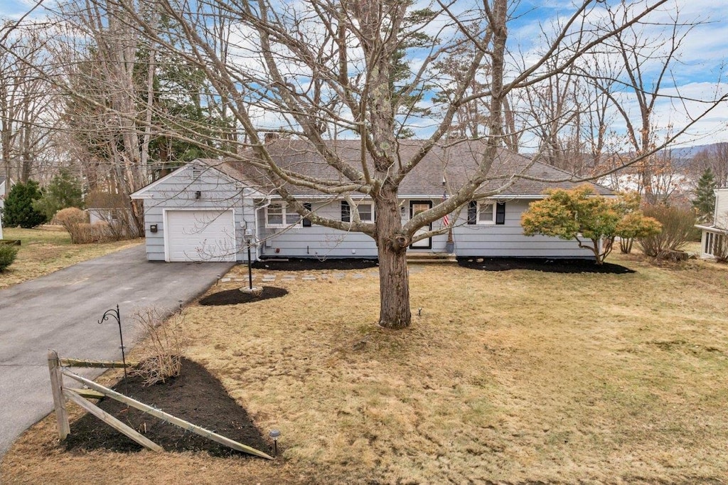 ranch-style house featuring aphalt driveway, a garage, and a front yard