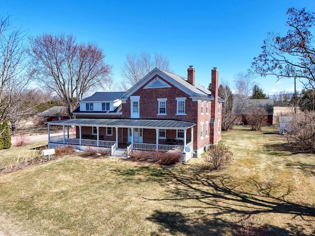 14 Adams Landing Rd, Grand Isle, VT 05458 - view of front facade featuring brick siding, a chimney, a front lawn, and a porch