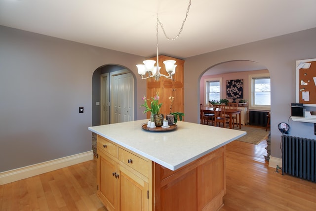 14 Adams Landing Rd, Grand Isle, VT 05458 - kitchen featuring light wood-style flooring, radiator, arched walkways, and a center island