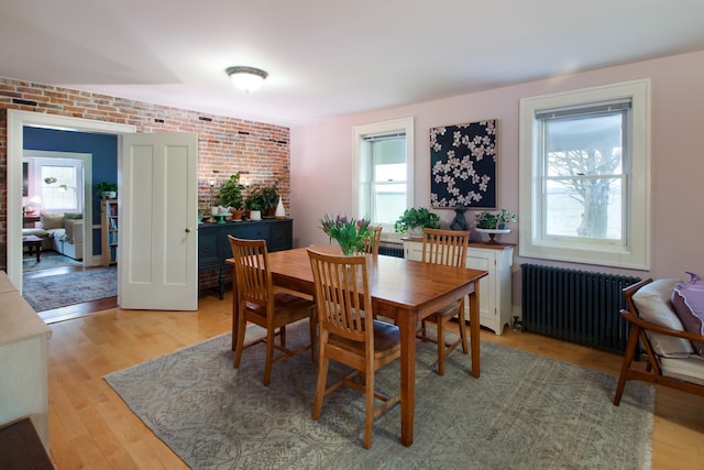14 Adams Landing Rd, Grand Isle, VT 05458 - dining space featuring radiator, brick wall, and light wood-type flooring