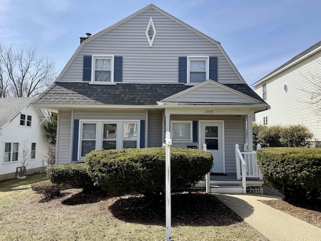 colonial inspired home with a gambrel roof and roof with shingles