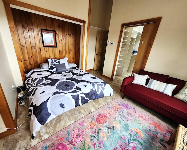carpeted bedroom featuring baseboards, a closet, and wooden walls