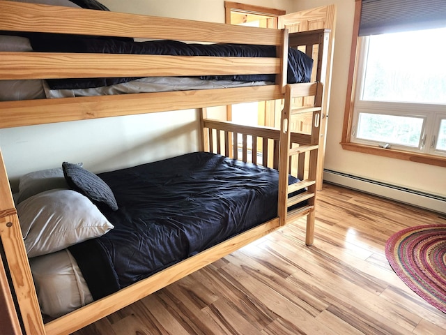 bedroom featuring wood finished floors and baseboard heating