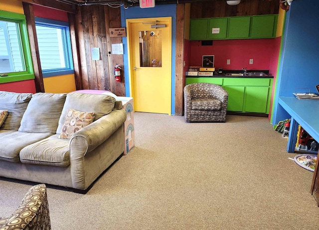 living area featuring wooden walls and light carpet